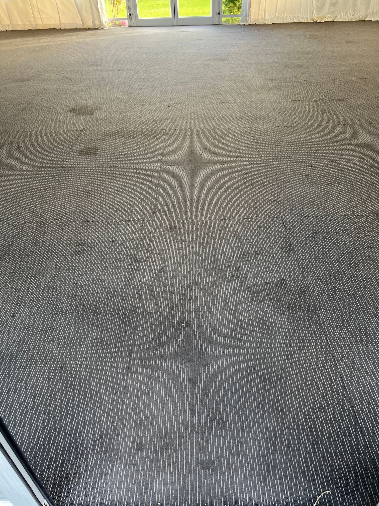 A close up of a black carpeted floor in a room.